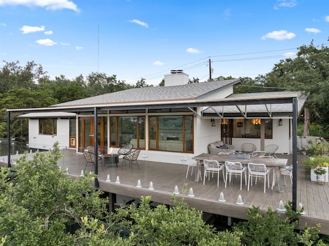 1400 Mount Larson Rd, Austin, TX 78746 - rear view of house featuring outdoor dining space, roof with shingles, a wooden deck, and a chimney