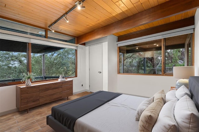 1400 Mount Larson Rd, Austin, TX 78746 - bedroom featuring rail lighting, wood finished floors, baseboards, and wood ceiling with exposed beams