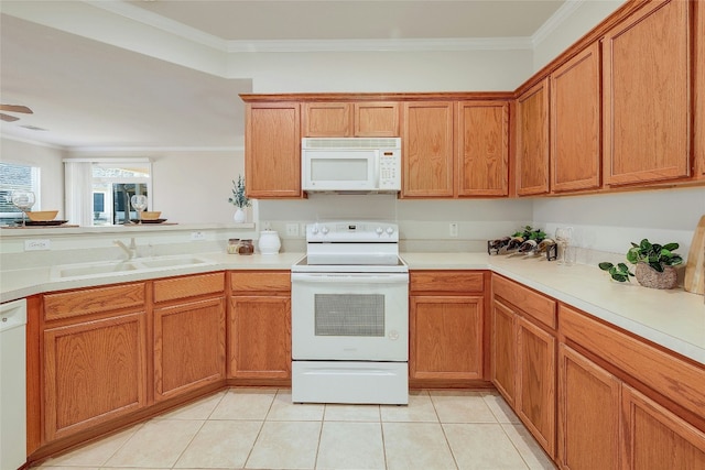 kitchen featuring light tile patterned floors, white appliances, a sink, light countertops, and crown molding