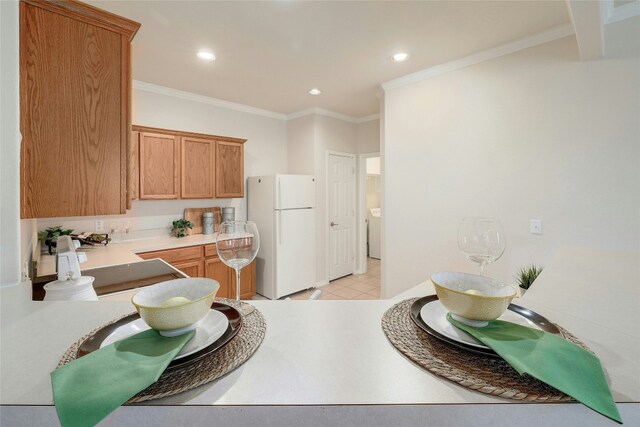 kitchen with recessed lighting, ornamental molding, washer / clothes dryer, and freestanding refrigerator