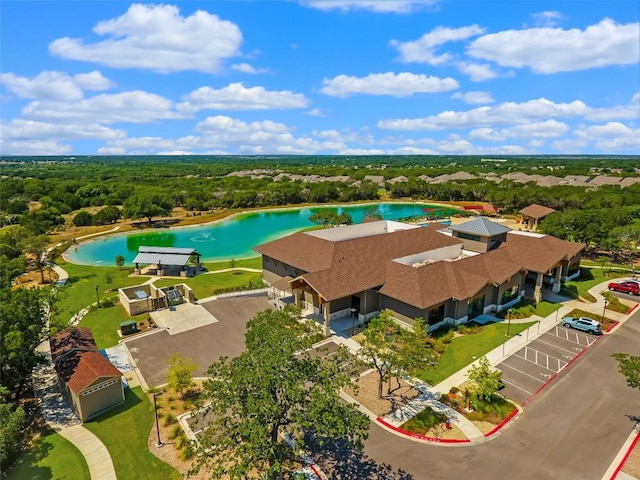 drone / aerial view featuring a water view and a forest view