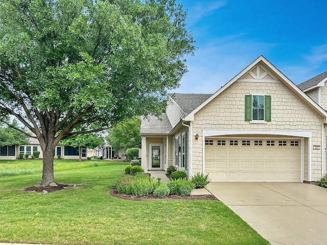 craftsman-style house with a garage, a shingled roof, a front yard, and concrete driveway