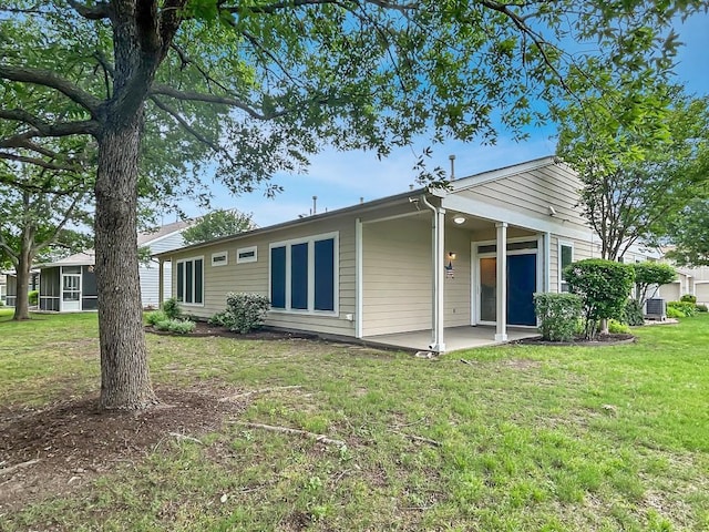 back of house with a yard and a patio