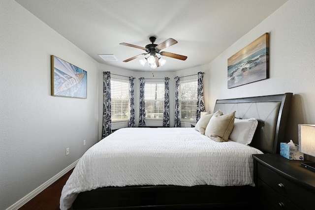 bedroom featuring ceiling fan, dark wood finished floors, visible vents, and baseboards