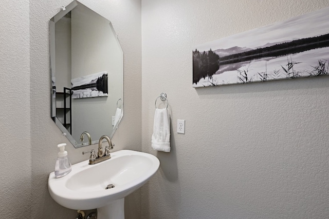 bathroom with a textured wall and a sink