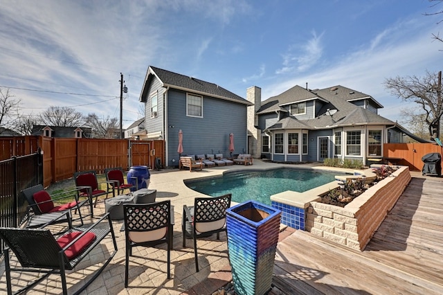 view of swimming pool featuring a fenced backyard, a wooden deck, a fenced in pool, and an outdoor living space with a fire pit