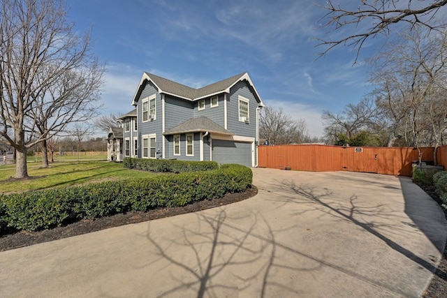 view of property exterior featuring driveway, a lawn, an attached garage, a gate, and fence