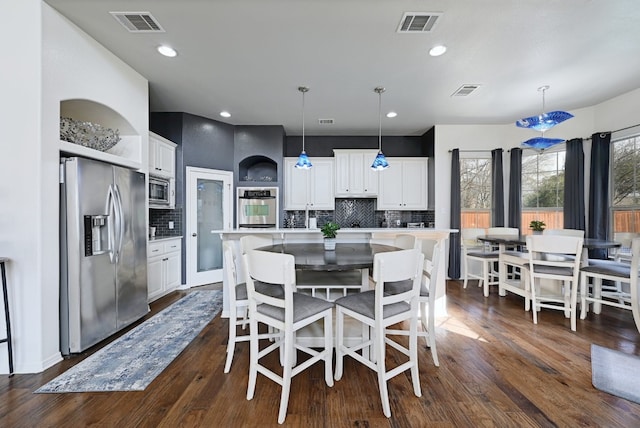 dining area featuring visible vents and dark wood finished floors