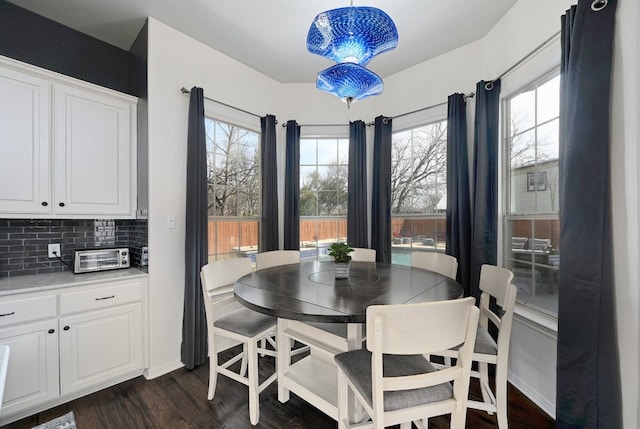 dining area with baseboards and dark wood-style flooring