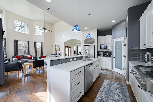 kitchen featuring appliances with stainless steel finishes, dark wood finished floors, visible vents, and a sink