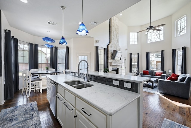 kitchen featuring dark wood-style floors, visible vents, a sink, and stainless steel dishwasher