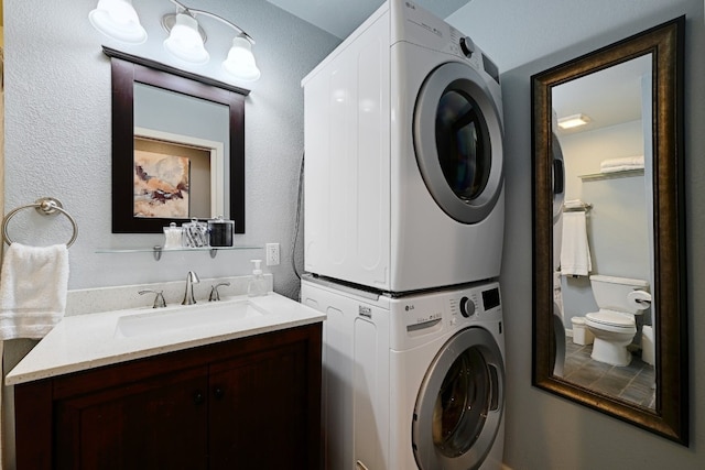 laundry room with laundry area, a sink, and stacked washing maching and dryer