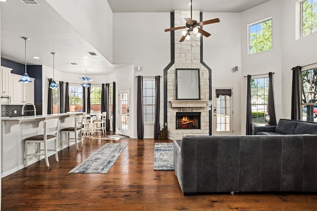 1601 Forest St, Georgetown, TX 78626 - living room featuring ceiling fan, a high ceiling, a fireplace, and dark wood finished floors