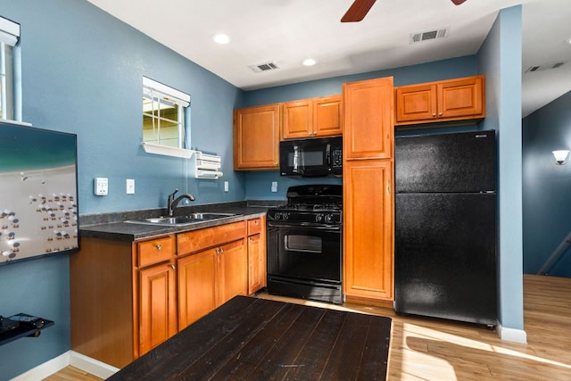 1601 Forest St, Georgetown, TX 78626 - kitchen with black appliances, a sink, a ceiling fan, light wood-type flooring, and dark countertops