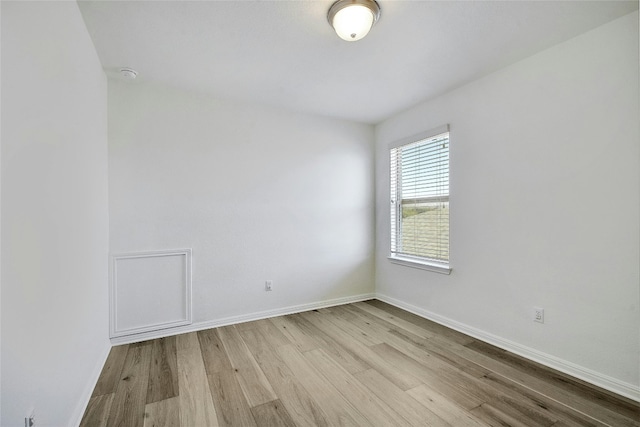 empty room with baseboards and wood finished floors