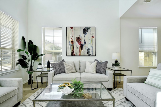 living room featuring light wood-style floors, baseboards, and plenty of natural light