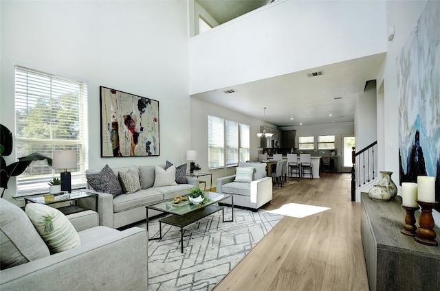 216 Iron Rail Rd, Dripping Springs, TX 78620 - living room with stairway, light wood finished floors, and a high ceiling