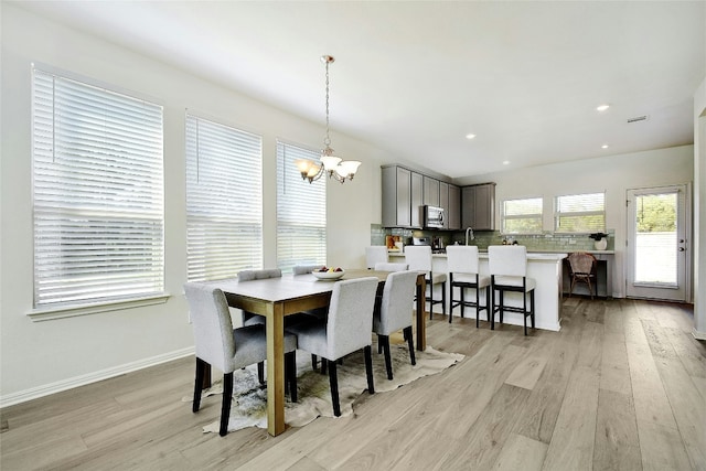 dining room with recessed lighting, baseboards, light wood finished floors, and a notable chandelier