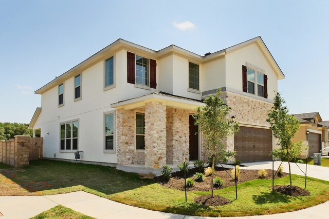 view of front of property featuring a garage, fence, a front yard, stucco siding, and driveway