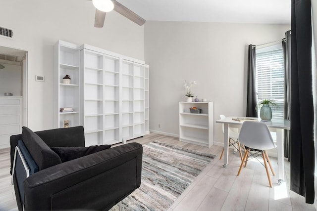 interior space featuring visible vents, a ceiling fan, vaulted ceiling, baseboards, and light wood-type flooring