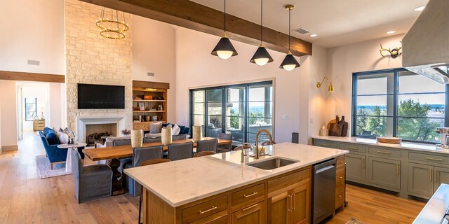 179 Lagrange Dr, Fredericksburg, TX 78624 - kitchen featuring light wood-style floors, ventilation hood, a center island with sink, stainless steel dishwasher, and a towering ceiling