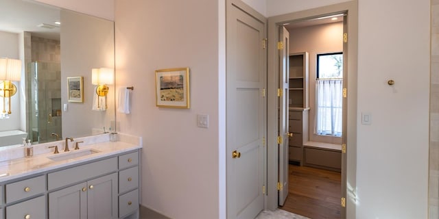 full bathroom featuring a shower stall, vanity, and wood finished floors