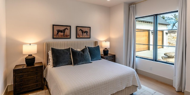 bedroom featuring light wood-style flooring and baseboards