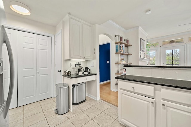 kitchen featuring dark countertops, white cabinetry, stainless steel refrigerator with ice dispenser, and open shelves