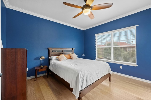 bedroom with ceiling fan, ornamental molding, wood finished floors, and baseboards