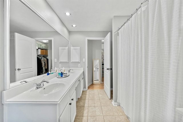 full bathroom with double vanity, tile patterned flooring, a sink, and recessed lighting