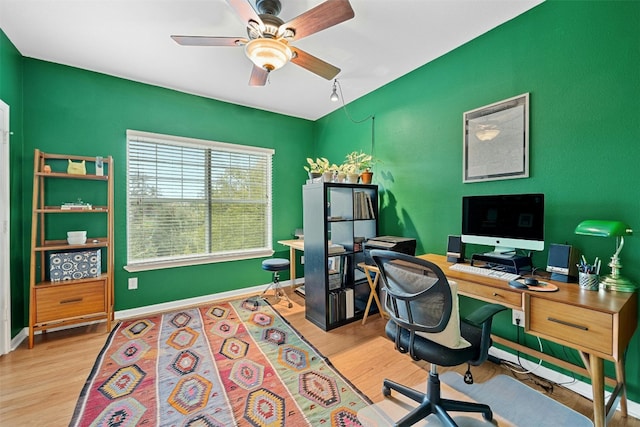 office space featuring ceiling fan, baseboards, and wood finished floors