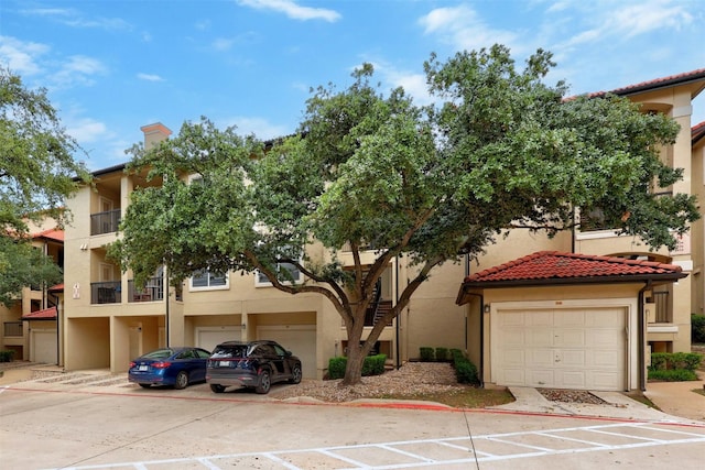 view of front of home featuring a garage, a tiled roof, and stucco siding