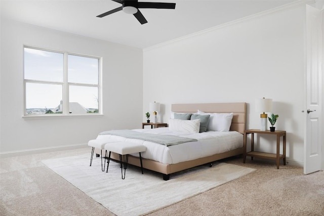 carpeted bedroom featuring ornamental molding, a ceiling fan, and baseboards