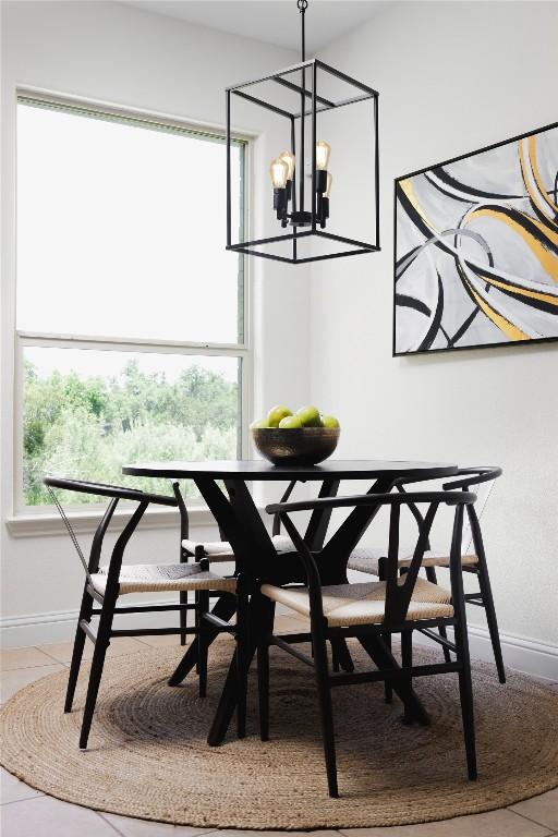 dining room with light tile patterned flooring, a notable chandelier, and baseboards