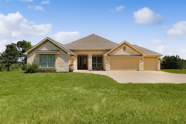 view of front of property featuring stone siding, a front yard, concrete driveway, and an attached garage