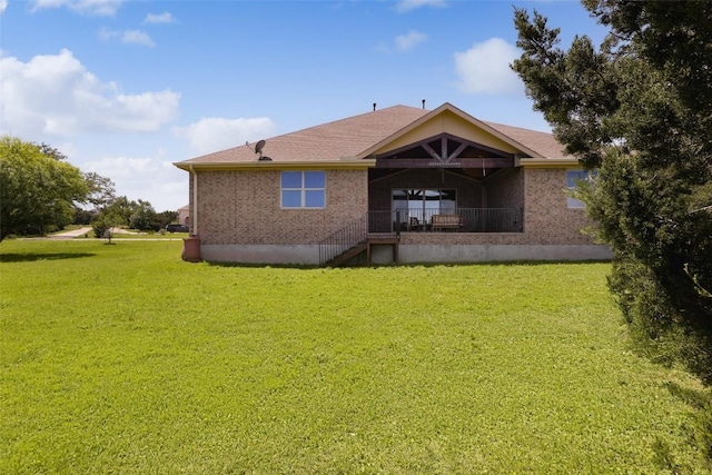 back of property with a yard and brick siding