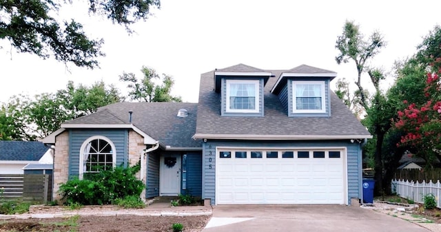 view of front of home featuring a shingled roof, fence, driveway, and an attached garage