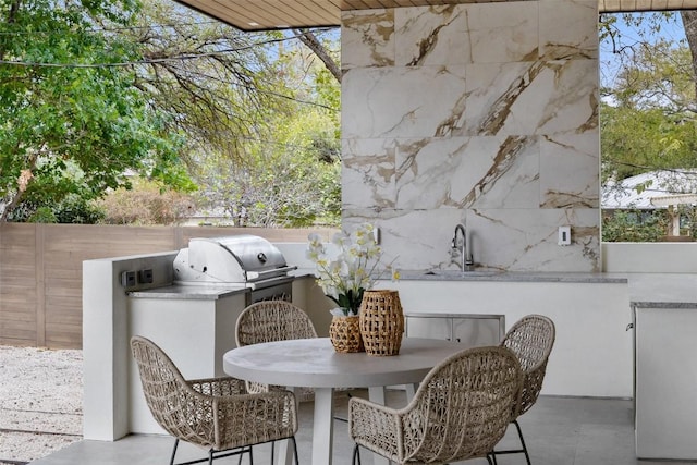 view of patio / terrace with fence, area for grilling, outdoor dining area, a sink, and grilling area