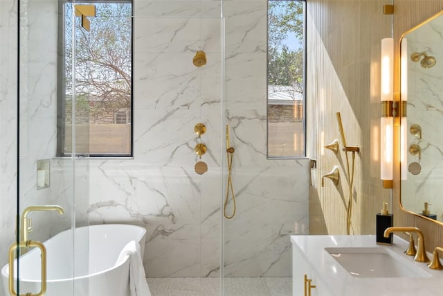 full bath with a freestanding tub, a marble finish shower, and vanity