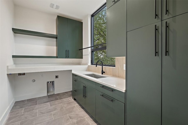 washroom featuring baseboards, cabinet space, electric dryer hookup, a sink, and hookup for a gas dryer