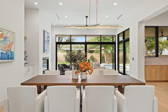 dining room featuring a wealth of natural light, light wood-type flooring, and recessed lighting