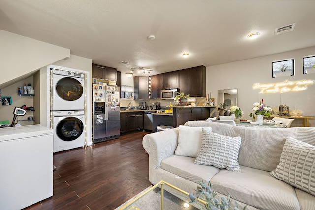 1811 Waterston Ave, Austin, TX 78703 - living room featuring stacked washer and clothes dryer and dark wood-style floors