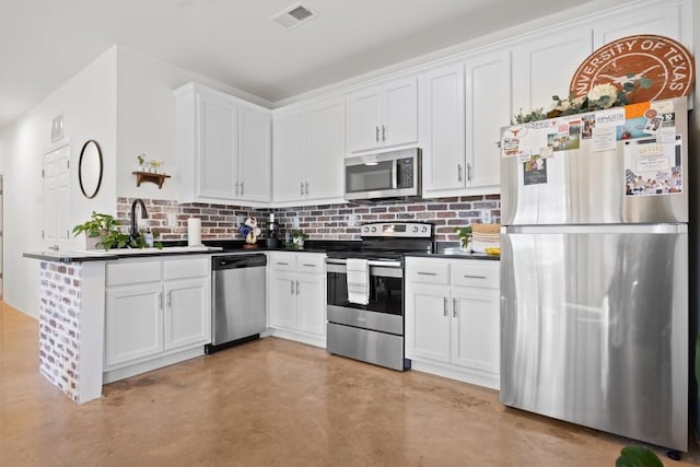 kitchen with stainless steel appliances, tasteful backsplash, finished concrete floors, white cabinetry, and a sink