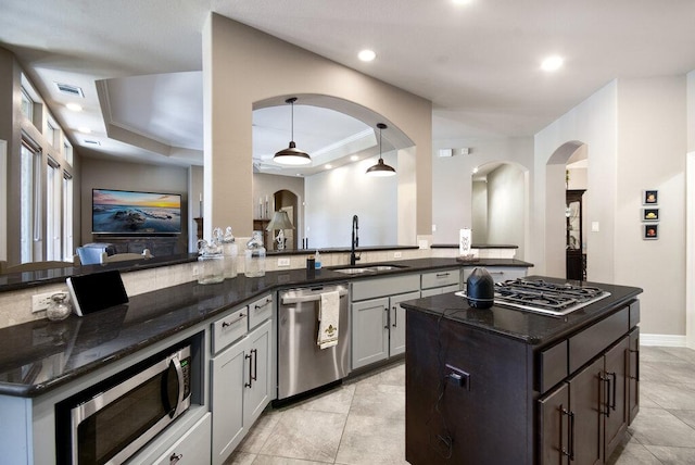 9512 Palmbrook Dr, Austin, TX 78717 - kitchen with appliances with stainless steel finishes, a sink, dark stone counters, arched walkways, and recessed lighting