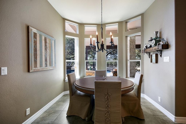 dining room featuring a chandelier, tile patterned floors, a textured wall, and baseboards