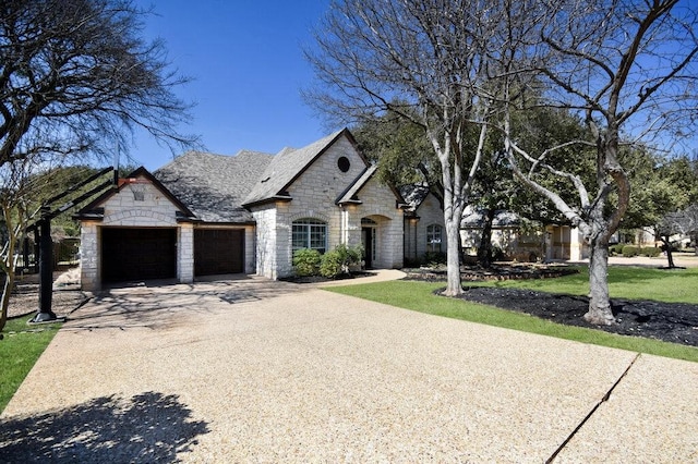 9512 Palmbrook Dr, Austin, TX 78717 - french country home with stone siding, an attached garage, and driveway