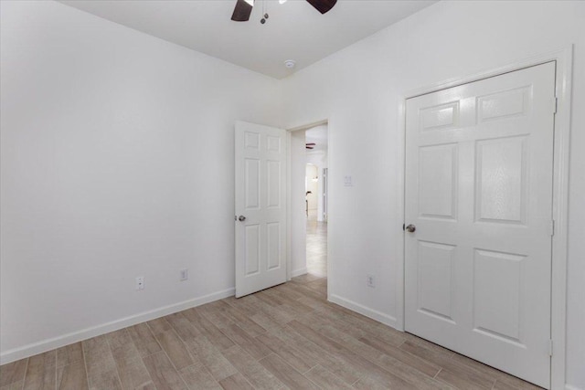 unfurnished bedroom featuring light wood-style floors, ceiling fan, and baseboards