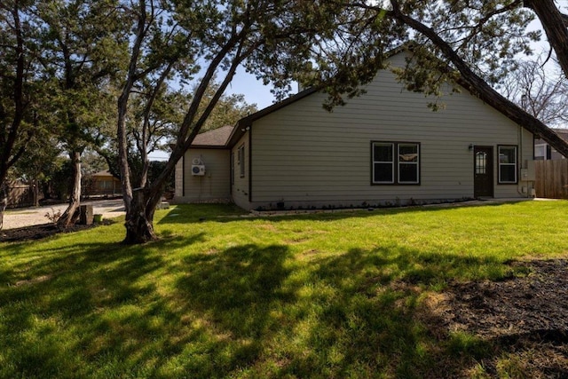 view of property exterior with fence and a lawn