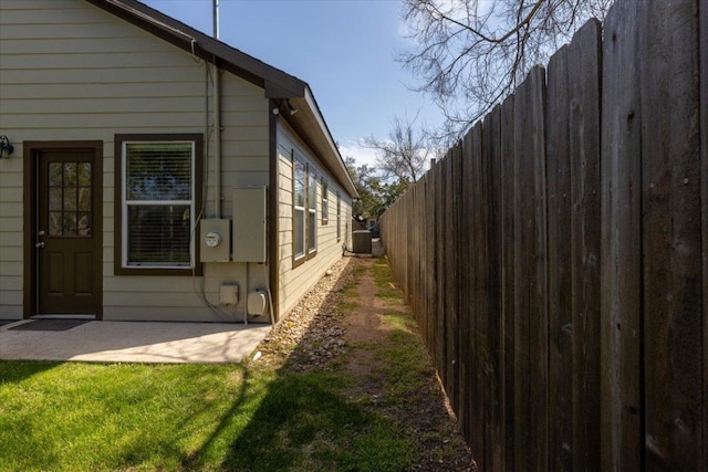 view of property exterior featuring fence, a lawn, and central air condition unit