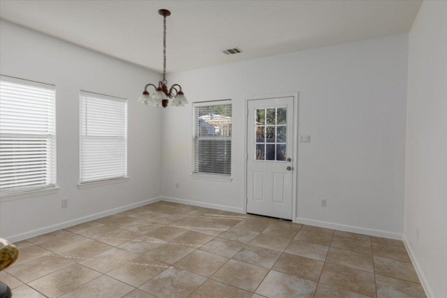 unfurnished dining area featuring a chandelier, light tile patterned flooring, visible vents, and baseboards